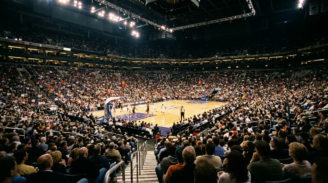 Pavilhão de basquetebol NBA iluminado durante um jogo nocturno visto da bancada